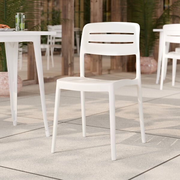 A white resin side chair with a slatted back design.