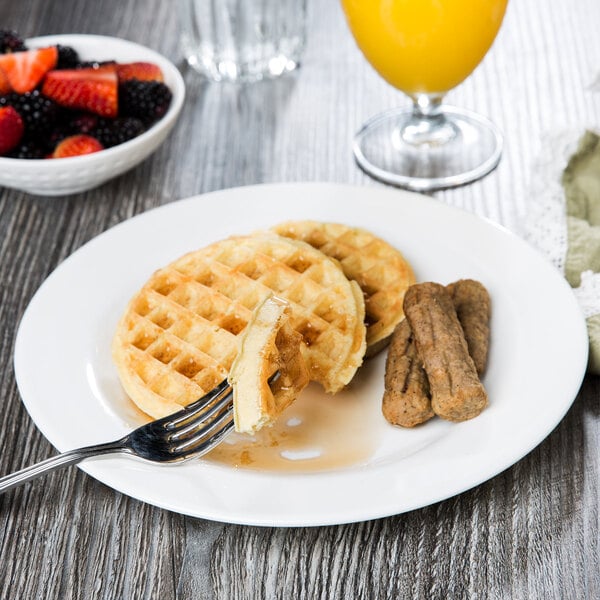 An Arcoroc glass brunch plate with waffles and fruit on it.