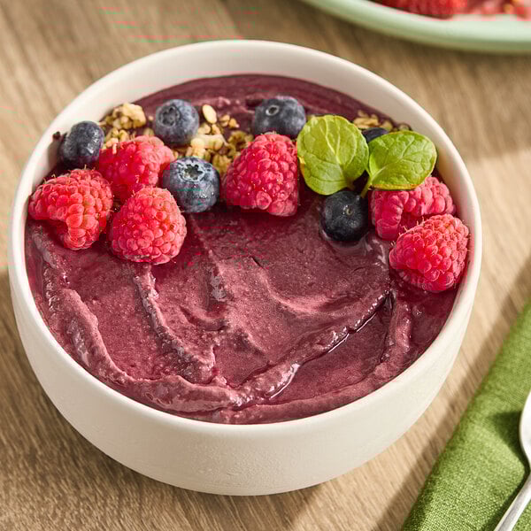 A bowl of acai and guarana smoothie topped with berries and nuts.