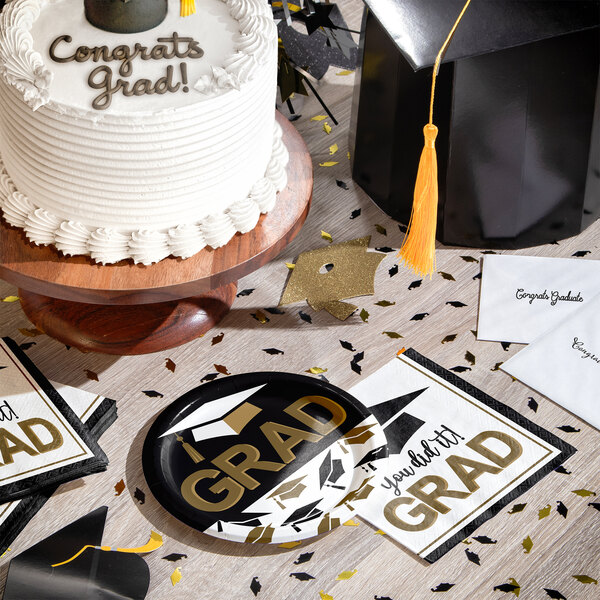 A round paper plate with a graduation theme and the words 'You Did It GRAD' in gold and black.