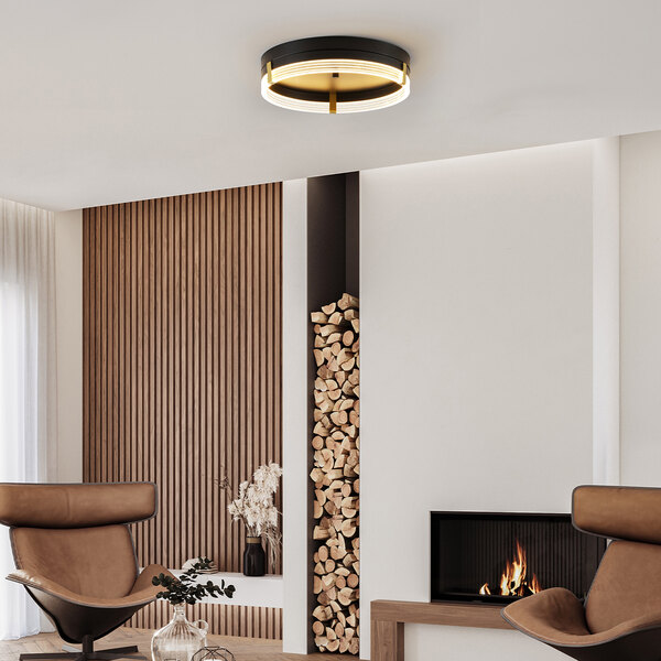 A modern flush mount ceiling light with an etched acrylic edge-lit shade and matte brass accents.