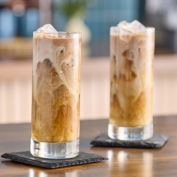 Two glasses of Numilk oat milk iced coffee on a table.
