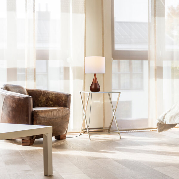A 20-inch table lamp with a two-tone faux wood base and a white cotton shade, placed on a small side table in a modern living room.