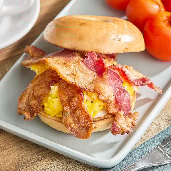 A bagel sandwich with Hatfield Chef Choice bacon and eggs on a plate.