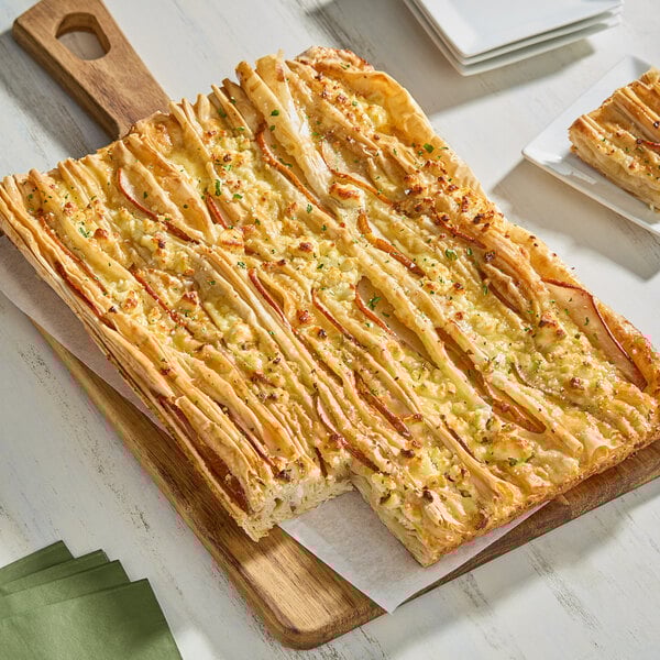 A rectangular piece of food on a wooden board.