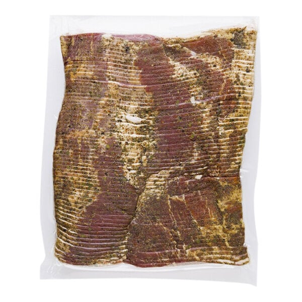 A vacuum packed Tender Belly bacon package with green and brown specks.