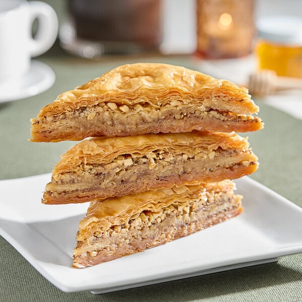 A stack of three Kontos Classic Baklava pastries on a plate.
