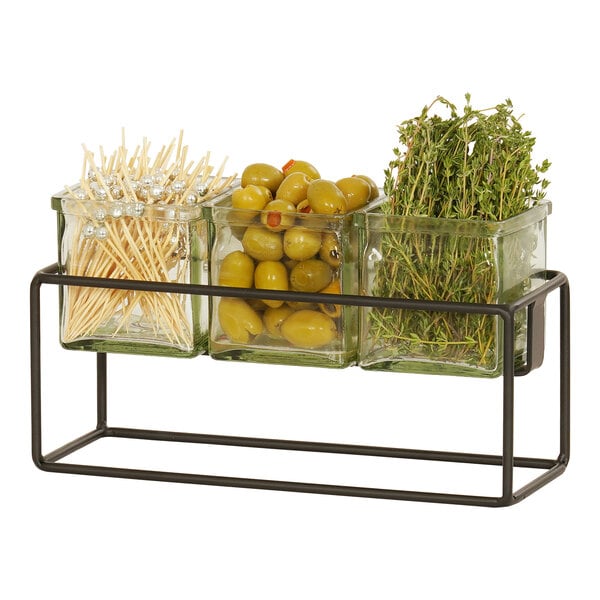 A black metal Cal-Mil condiment display with three square glass jars filled with green olives.