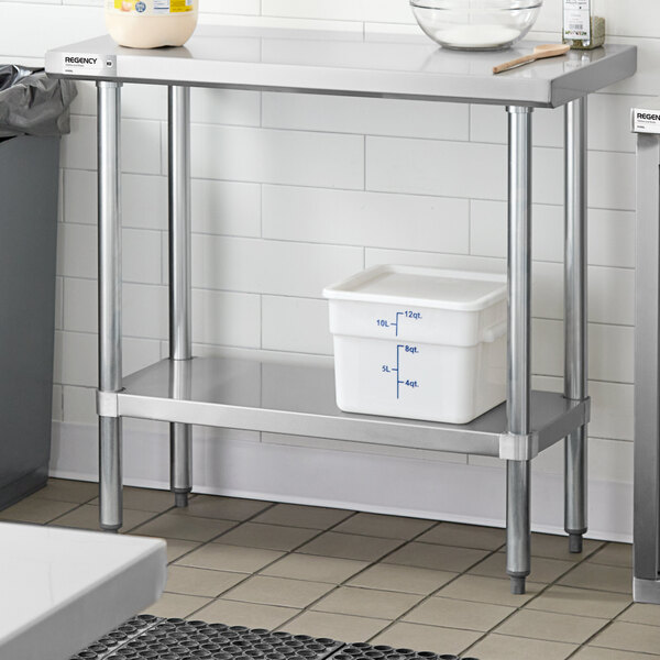 A stainless steel work table with an adjustable undershelf, holding a white storage container with measurement markings.