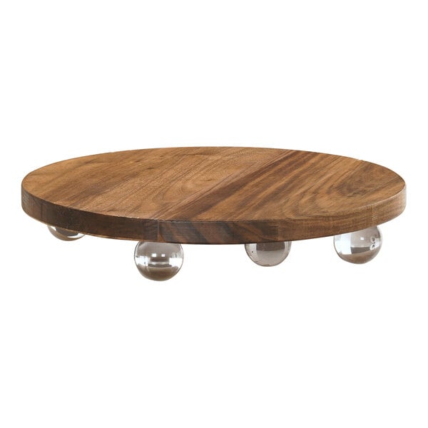 A Cal-Mil walnut wood round display stand with clear balls on a wood surface.
