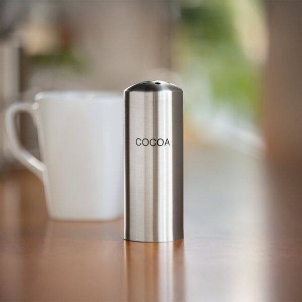 A stainless steel round container with a teardrop hole lid filled with salt.