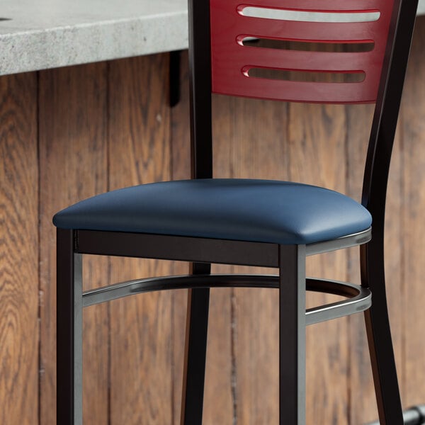 A Lancaster Table & Seating navy vinyl padded seat on a metal frame chair.