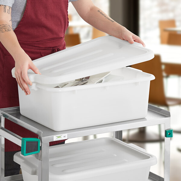 A white polypropylene bus tub with a lid, placed on a metal cart.