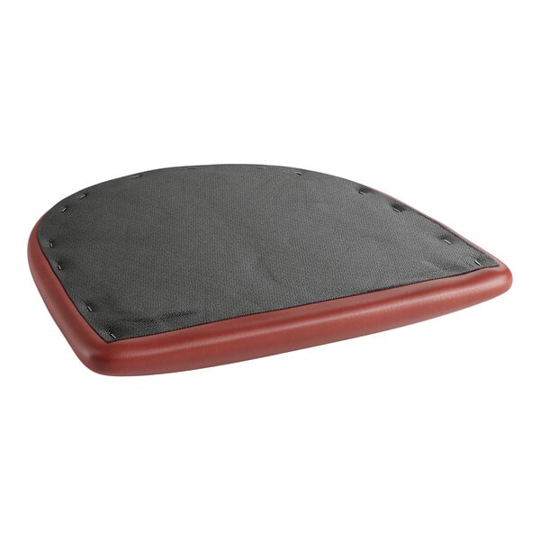 A close-up of a Lancaster Table & Seating burgundy vinyl padded seat cushion with black trim.