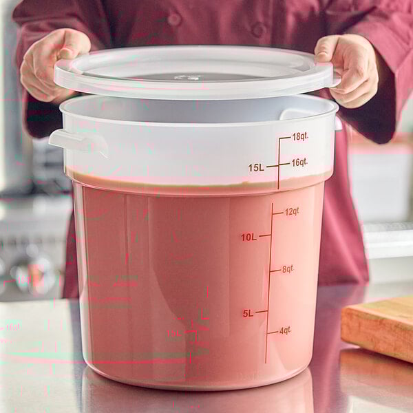 A large translucent round polypropylene food storage container with a lid and red measurement markings.