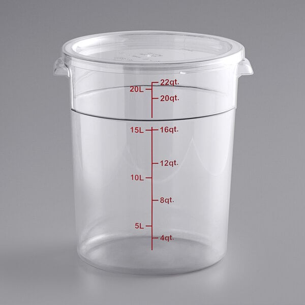 A clear round polycarbonate food storage container with a lid and red measurement markings up to 22 quarts.
