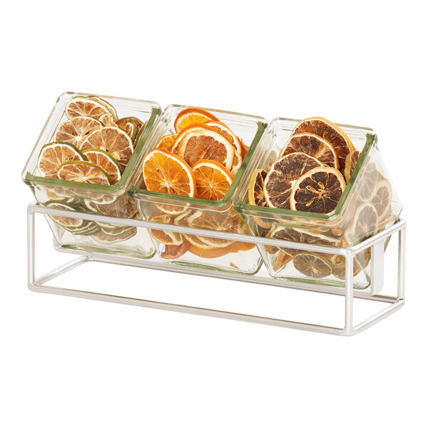 A Cal-Mil chrome condiment display with three square glass jars containing slices of oranges and lemons.