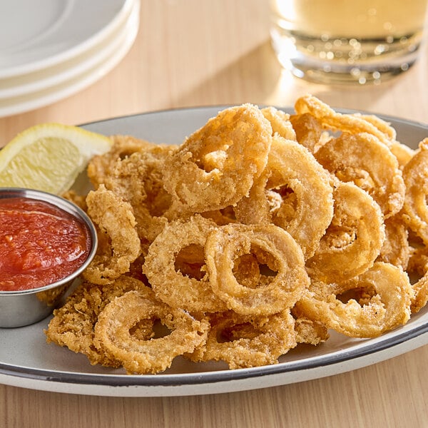 A plate of Jinka plant-based breaded calamari with sauce and lemon.