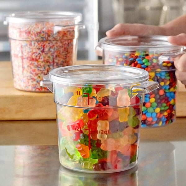A clear round polycarbonate food storage container with a lid, filled with gummy bears.
