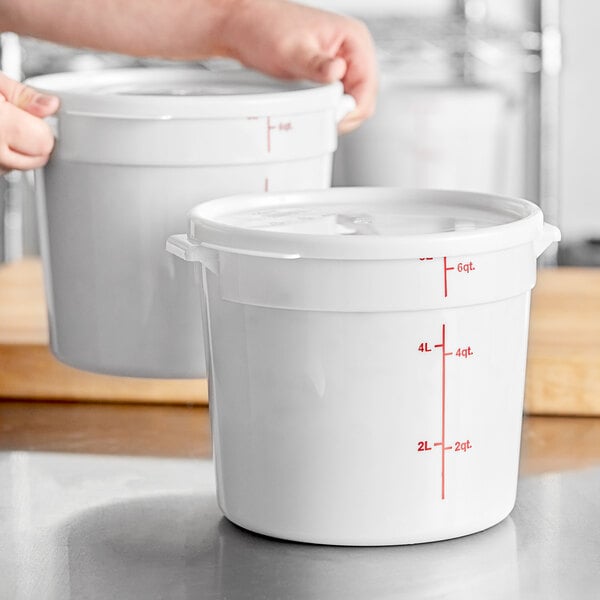A white round 6-quart polypropylene food storage container with a lid and red measurement markings.