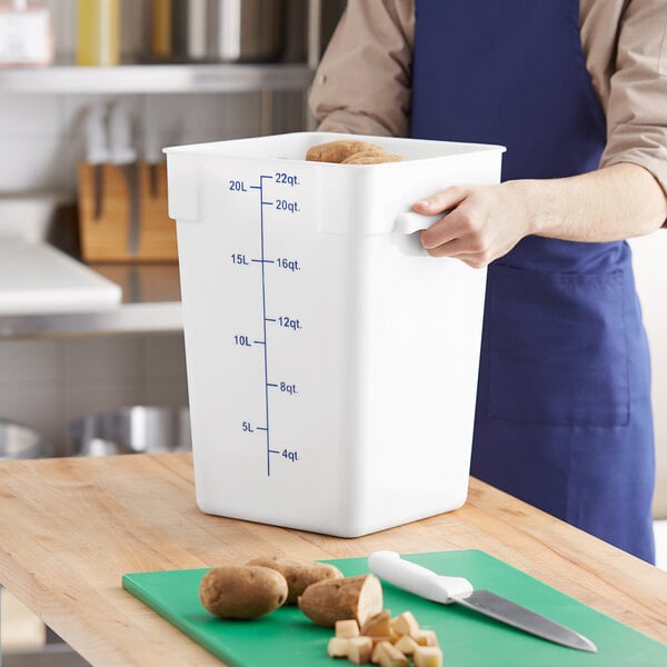 A large white square polypropylene food storage container with blue measurement markings and a blue lid.
