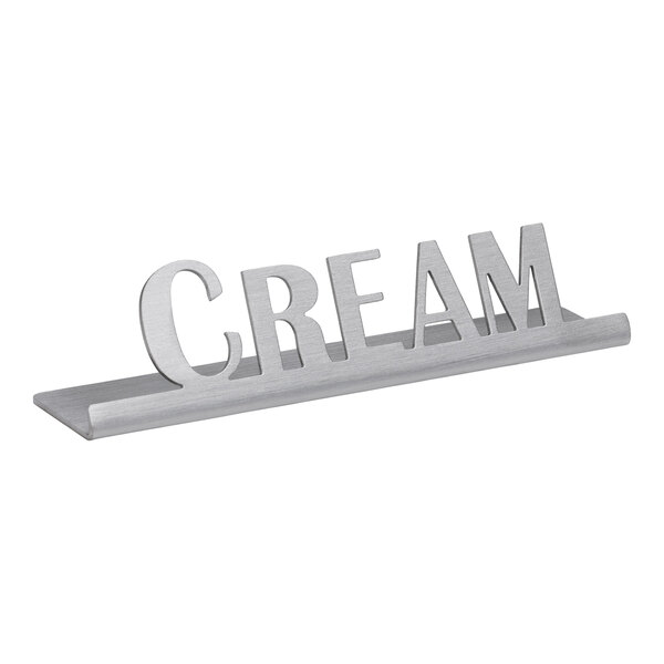 A brushed stainless steel metal plaque with the word "cream" on it.