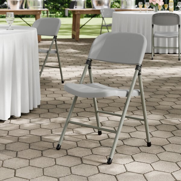 A gray contoured injection-molded folding chair with a charcoal frame and gray legs.