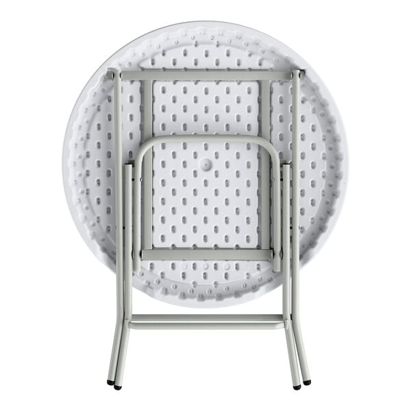 A round, granite white plastic folding table with gray metal legs shown in a folded position.