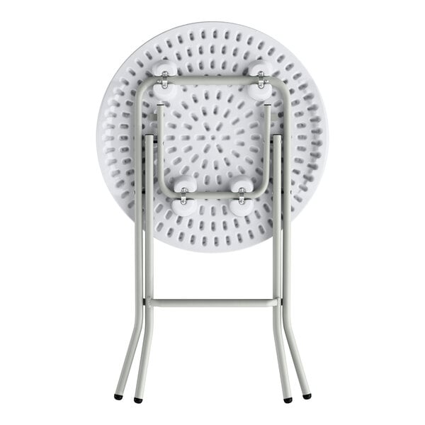 A round, granite white plastic folding table with gray metal legs in a folded position.