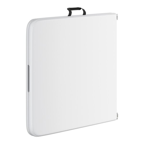 A white rectangular plastic folding table with a black handle.