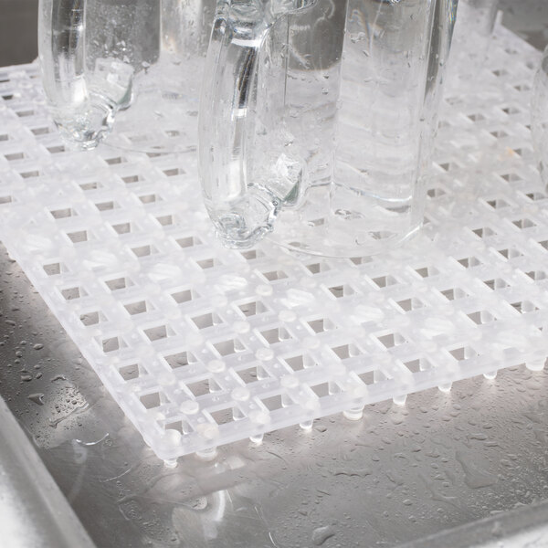 A clear glass on a Choice clear plastic bar mat.