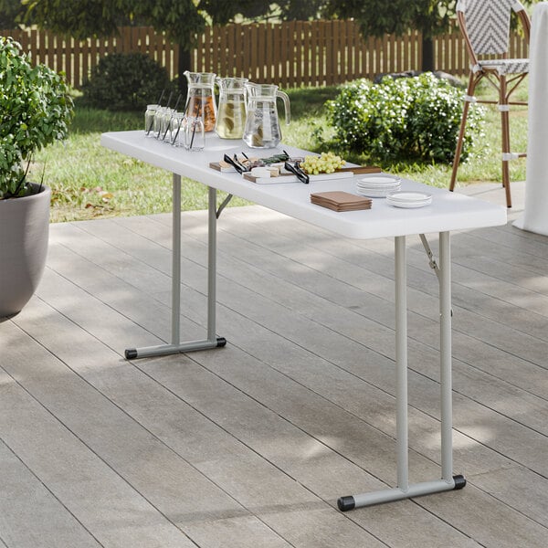 A rectangular granite white heavy-duty blow-molded plastic folding table with gray metal legs.
