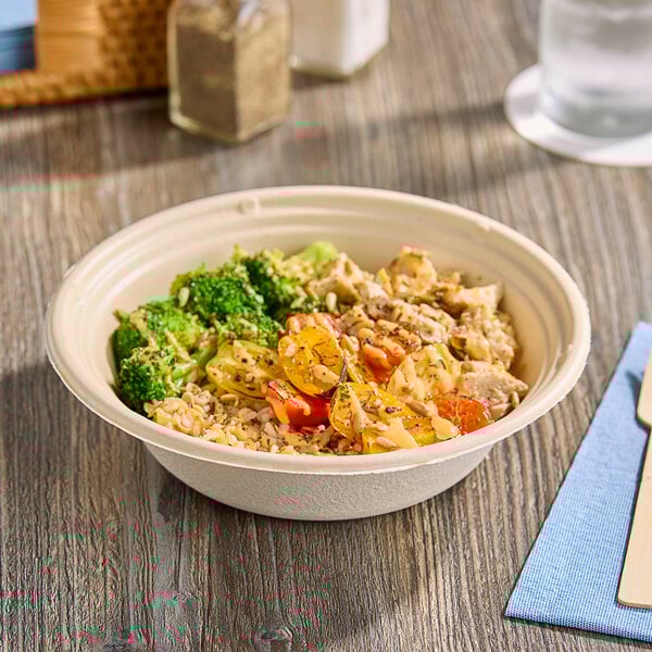 A Tellus Products Elite 24 oz. coated fiber bowl of food on a table.