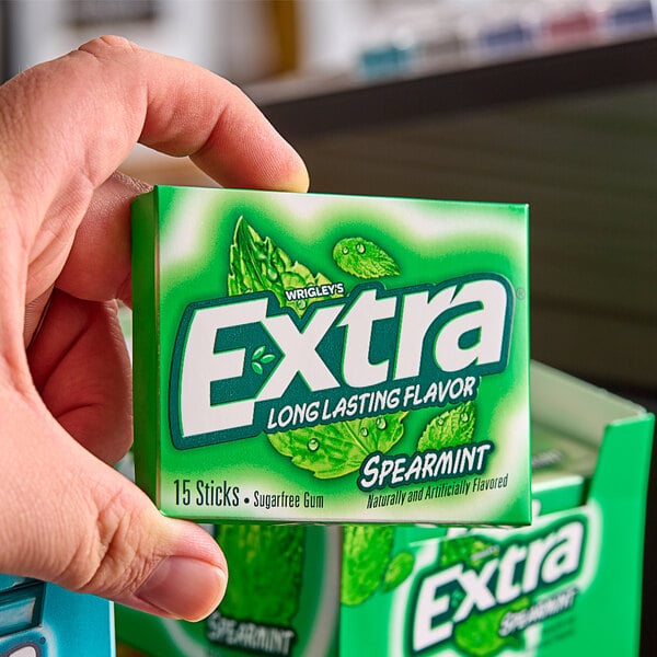 A hand holding a Wrigley's EXTRA Spearmint Gum 10-pack.