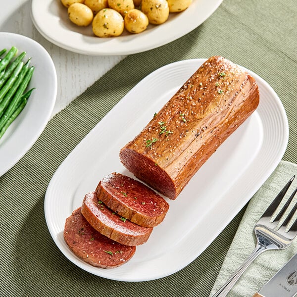 A plant-based vegan whole-cut loin partially sliced and served on a white platter.