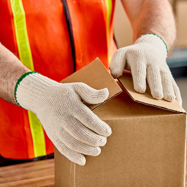 A person wearing Lavex work gloves opening a box.