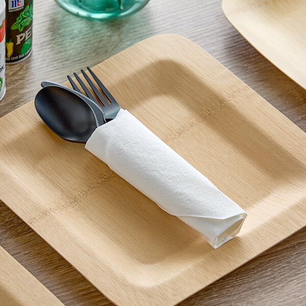 A spoon and fork wrapped in a white Morcon Morsoft napkin.