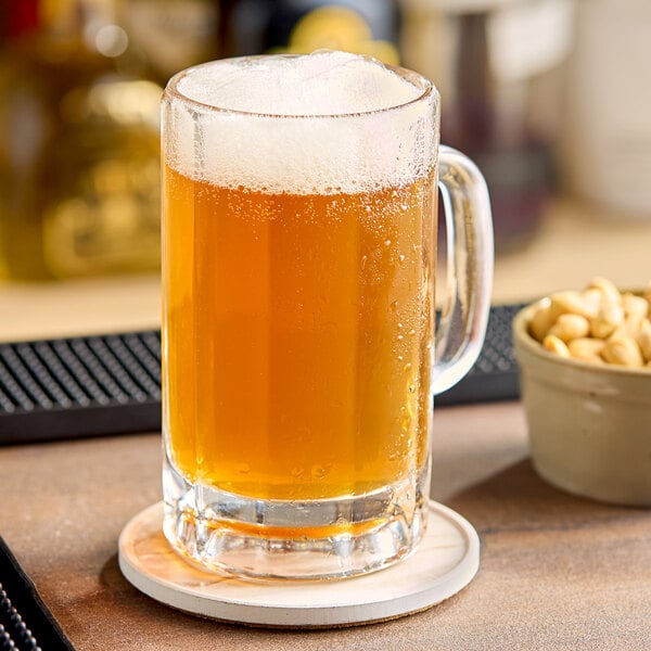 A glass of beer with foam on a wooden bar.