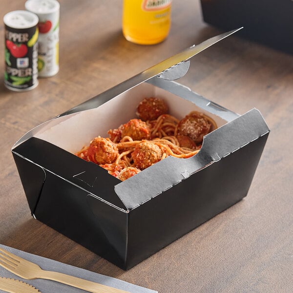 A Southern Champion black paper take-out box filled with spaghetti and meatballs.