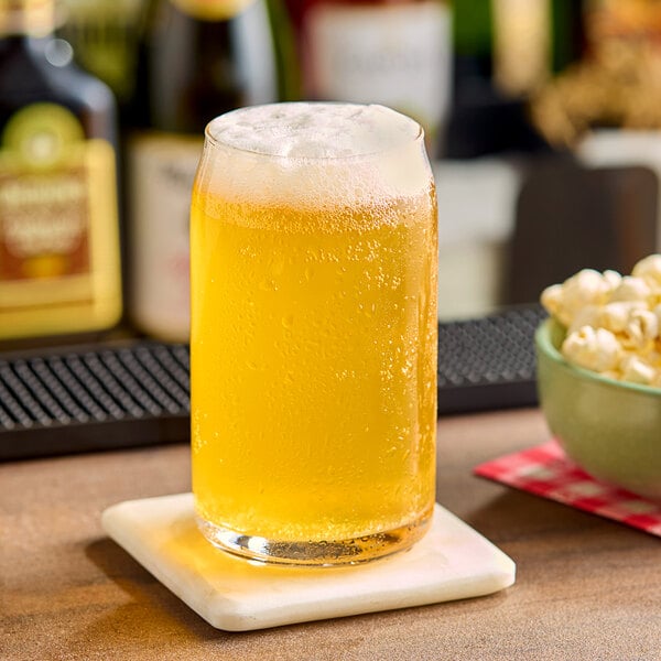 A glass of Hopzoil MAJIK® Citrus Fruitbomb™ Hop Extract in a glass of beer on a white table.
