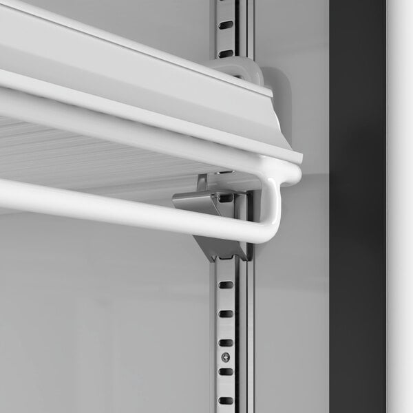 A close-up view of an adjustable white shelf inside a glass door merchandiser refrigerator.