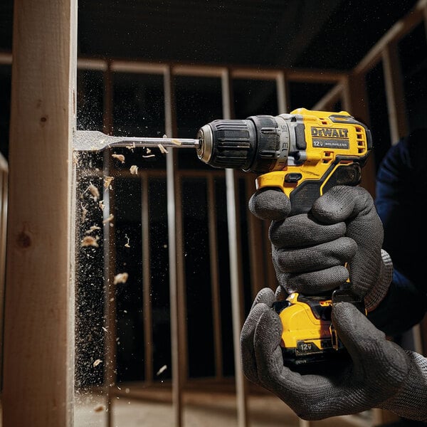 A man using a DeWalt cordless drill to drill wood.