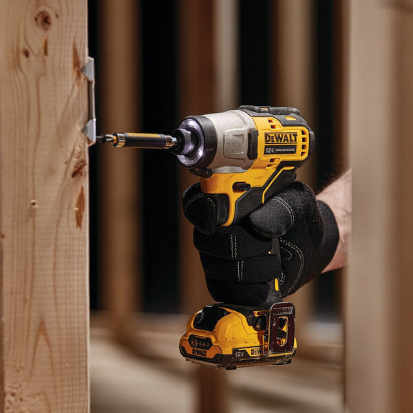 A hand holding a yellow and black DeWalt 12V cordless drill/driver.