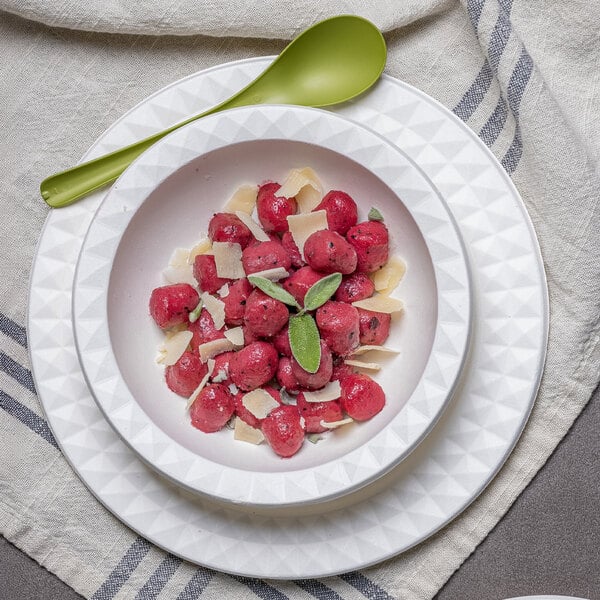 A Jungle Decor sugarcane pulp plate with food in a bowl and a spoon.