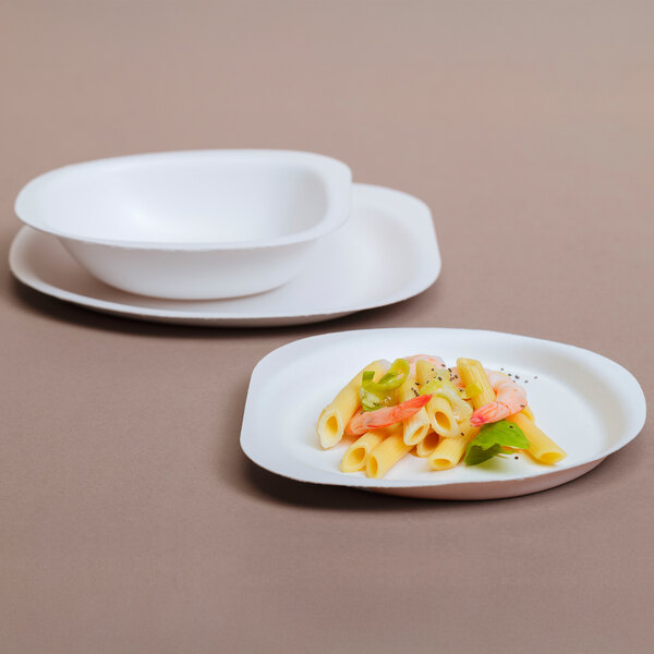 A white bowl of pasta with shrimp and vegetables.