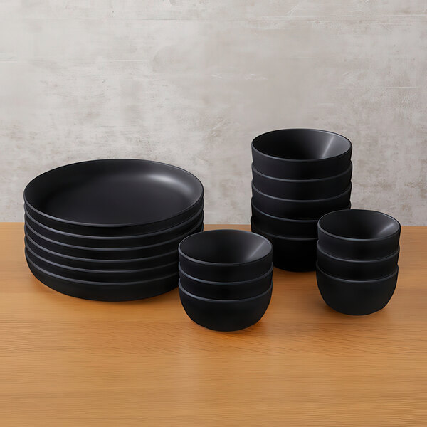 A stack of American Metalcraft black melamine bowls on a table.