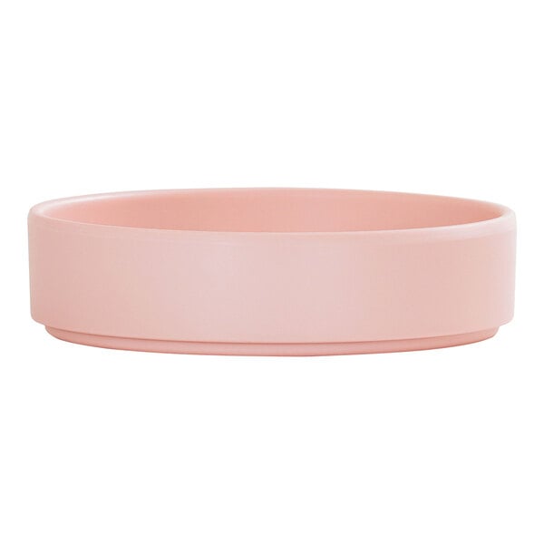 A round, blush-colored melamine plate with a raised rim.