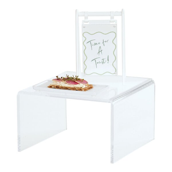 A small clear acrylic U-shape display riser holding a sandwich.