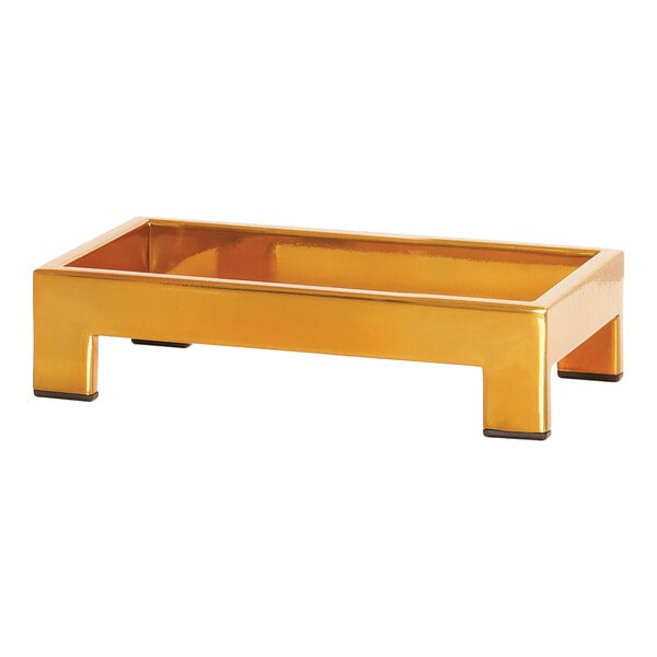 A gold rectangular Cal-Mil display riser with black legs.