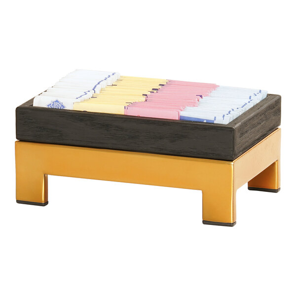 A brass metal display riser with colorful cards on it.